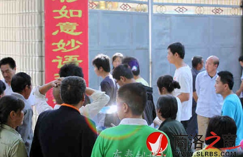 家們送考生進(jìn)入考場(chǎng)時(shí)，一縷光環(huán)閃現(xiàn)鏡頭中，這也許就是人們的理想與期待.jpg