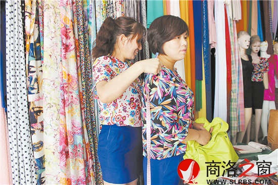 雷小莉仔細地為客人量尺寸，量體裁衣是裁縫鋪最大的優(yōu)勢。