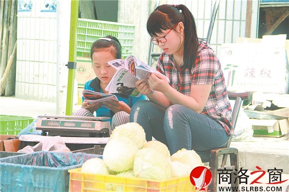商州區(qū)楊斜鎮(zhèn)集市上，南思佳和妹妹在幫父母賣菜，閑暇之余，她們會拿起課外讀物翻一翻。在這個假期里，她們呆的最多的地方就是這個菜攤。